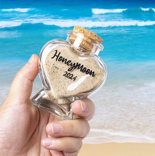 Heart-shaped jar with sand labeled Honeymoon 2024