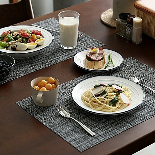 Table setting with spaghetti, salad, toast, milk, and fruit.