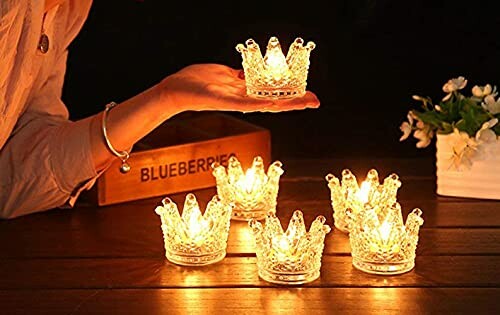 Crown-shaped tealight candles lit on a table