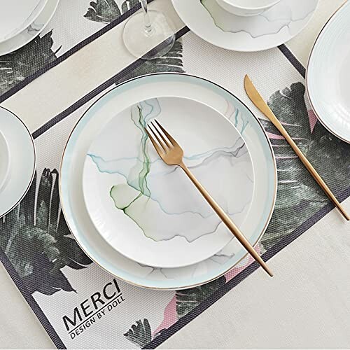 Elegant dining table setting with plates and a gold fork.