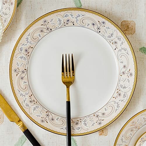 Elegant plate with gold fork on patterned tablecloth