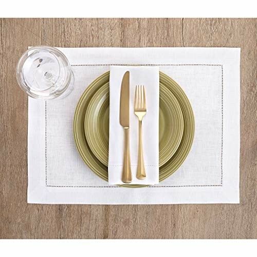 Elegant table setting with green plates, gold cutlery, and glass on wooden table.