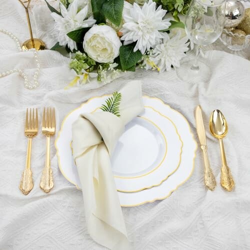 Elegant table setting with gold cutlery and floral decor.