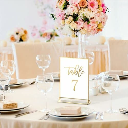 Elegant wedding table setting with floral centerpiece and table number seven.