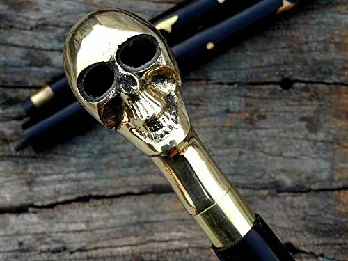 Gold skull cane handle on wooden surface