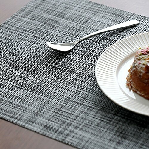 Gray table mat with a plate and dessert, accompanied by a spoon.