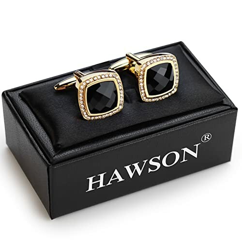 Gold and black cufflinks on a Hawson box