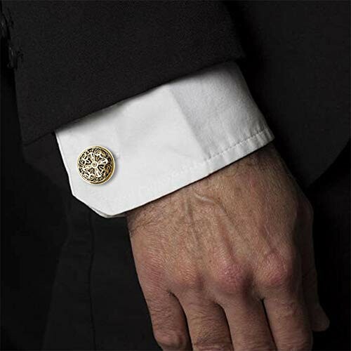 Man's hand in black suit with ornate cufflinks.