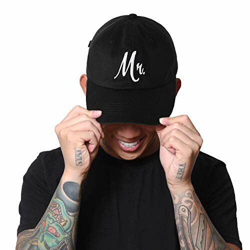 Person with tattoos wearing a black cap with 'Mn' on it