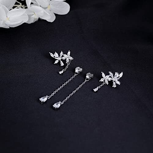 Silver floral drop earrings on black background