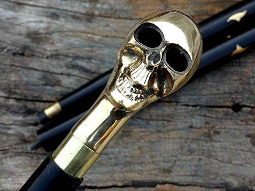 Walking stick with a gold skull handle on wooden background.