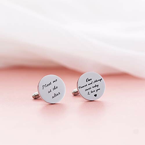 Two round wedding cufflinks with engraved messages on a pink surface.