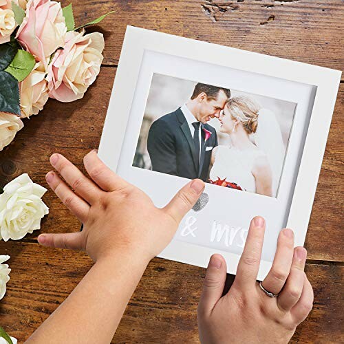 Hands holding a wedding photo frame with a couple inside.