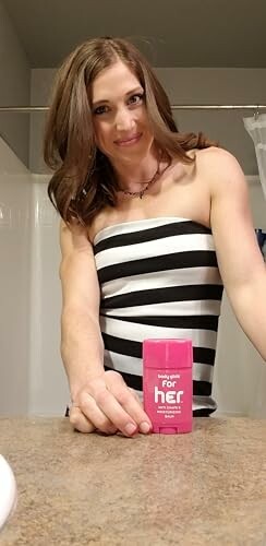 Woman in striped dress holding pink deodorant